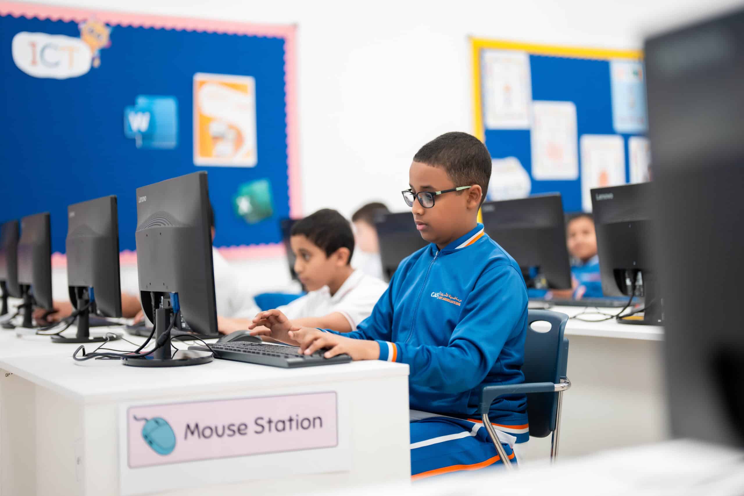 A student writing code on a laptop during a computer-science lesson