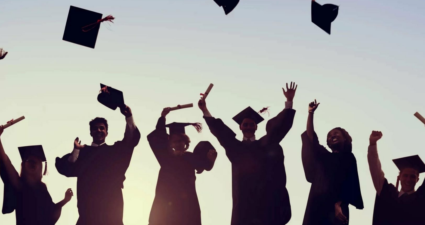 Graduating students in caps and gowns celebrating at a commencement ceremony